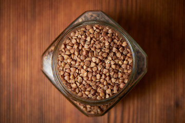 buckwheat in a jar closeup on a brown wood background