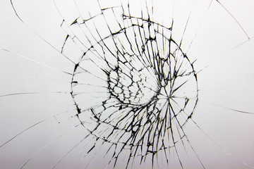 Cracked glass on white background texture. Broken glass. Cracks from impact or shot.