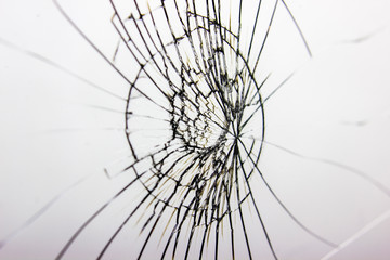 Side view, selective focus. Cracked glass on white background texture. Broken glass. Cracks from impact or shot.