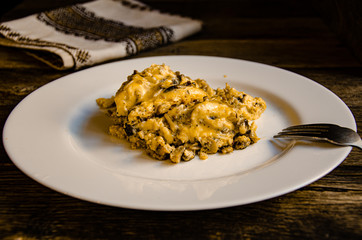 Omelet with mushrooms on a white plate on a wooden table.