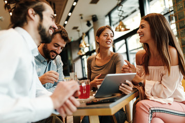 Group of Happy friends having with digital tablet in cafe