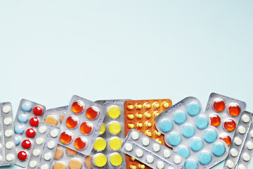 Lots of Blisters with color cough drops on blue background. Place for text..Medicine concept.