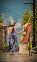 Girl with a cello looks at the mountains. © Don_Rebe