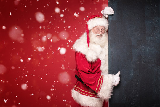 Real Santa Claus holding black empty board.