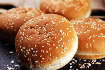 Fresh homemade burger buns with sesame on dark background
