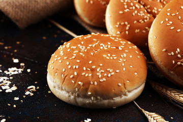Fresh homemade burger buns with sesame on dark background
