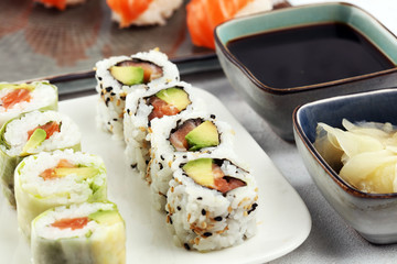 close up of sashimi sushi set with chopsticks and soy - sushi roll with salmon and sushi roll with smoked eel