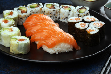 close up of sashimi sushi set with chopsticks and soy - sushi roll with salmon and sushi roll with smoked eel