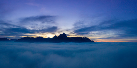 Fototapeta na wymiar cloudy sunset panorama over clouds with view to mountain chain hahenkamm at reutte