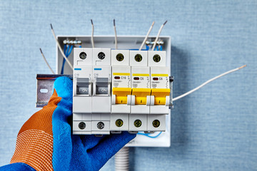 Installing a circuit breakers on the DIN rail.