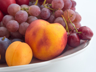 Isolate.Porcelain plate on a white background.On a plate lie juicy ripe fruit