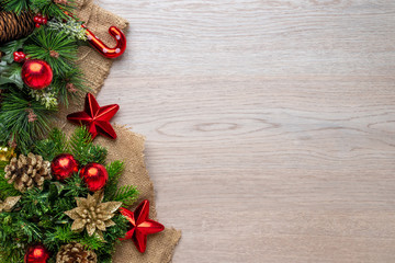 Christmas decorations on an old cloth and wooden surface. Shiny balls, stars and pine cones. Copy space beside. Tp view, flat lay.