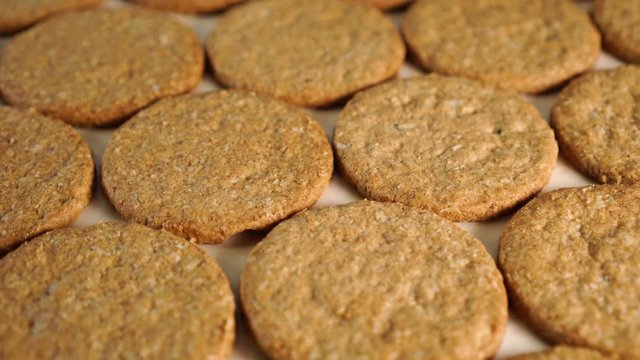 Neatly folded oatmeal cookies rotate on a wooden board. Making a healthy breakfast