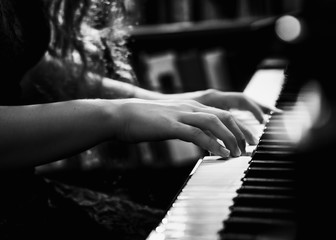 Black and White Photo of Young Lady Playing the Piano