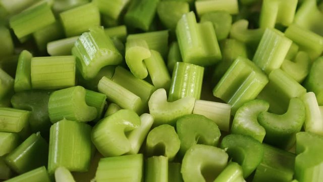 A bunch of slices of chopped fresh celery rotate. Making a nutritious cocktail to cleanse the body