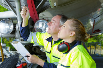 airport workers check an aircraft for safety