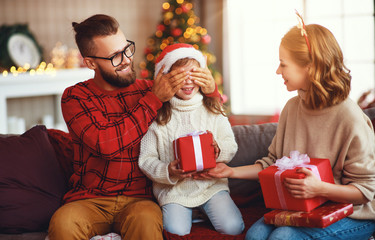 Fototapeta na wymiar happy family with gifts near Christmas tree at home.