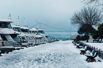 Istanbul, Uskudar / Turkey - 15Feb2015: a couple walking by the seaside with holding hands on a cold snow day at Istanbul Bosporus