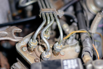 Obraz premium Man mechanic works in the garage. Repairs the engine of an old car