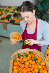Obraz premium beautiful woman choosing oranges in supermarket