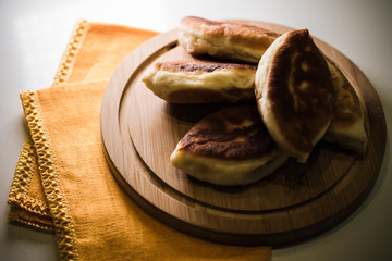 Pies on a wooden board and orange napkins