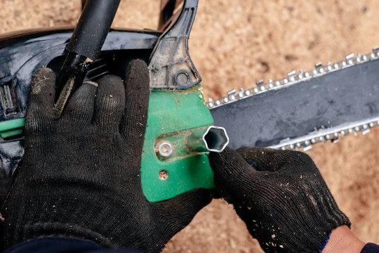 Professional Technician Working By Repair Service.Repairing Chainsaw In Repair Shop.