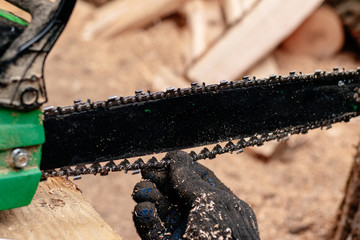 Professional technician working by repair service.Repairing chainsaw in repair shop.