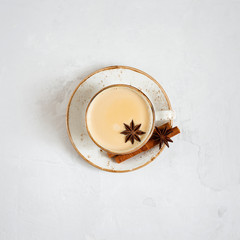 Indian Masala chai tea. Traditional Indian hot drink with milk and spices on white concrete...