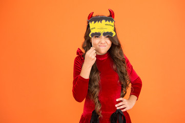 Freakishly scary Halloween. Scary halloween child orange background. Party girl with scary look. Fashion kid wear red devil horns and props. Scary holiday season