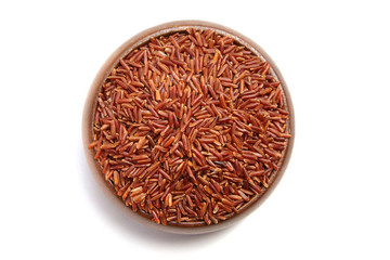 Fototapeta na wymiar Red rice in a brown wooden bowl isolated on white background. Dry uncooked cereal grains, ingredient for cooking various dishes