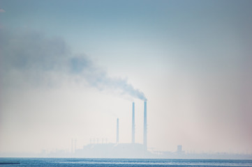 Thermal power plant in a haze on the lake