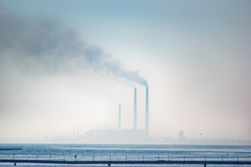 Obraz premium Thermal power plant in a haze on the lake