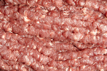 Ground beef texture background. Uncooked mincemeat. Forcemeat, fresh raw minced meat, top view