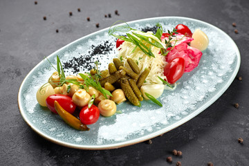 Marinated vegetables with mushrooms on a dark background
