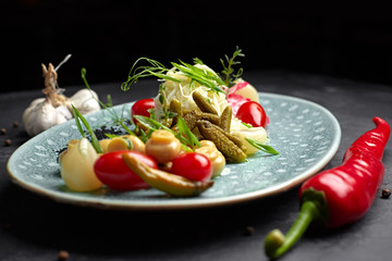 Marinated vegetables with mushrooms on a dark background