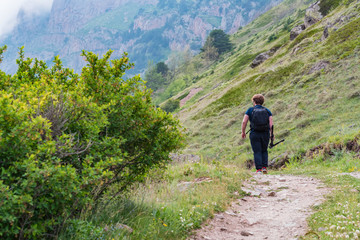Obraz premium Back view male hiker walks in beautiful mountains in North Caucasus
