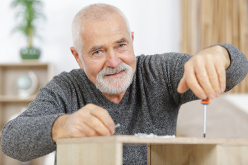 mature man assembling bed in new home