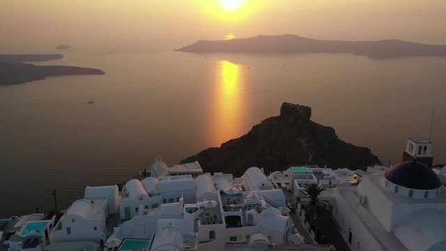 Aerial drone video of beautiful sunset over picturesque village of Imerovigli and main church with beautiful golden colours, Santorini island, Cyclades, Greece