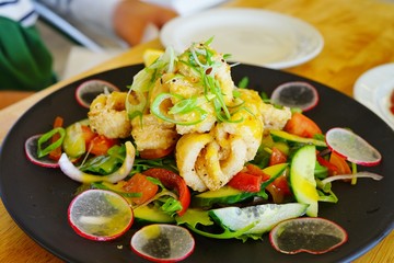 Tasty salad with fried calamari