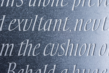 Generic words carved from dark stone with sideways lighting.