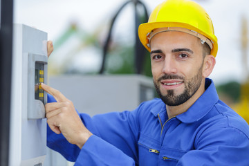 young smiling electrician standing outdoors