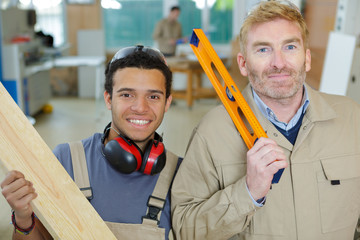 two men working together to build wooden frame