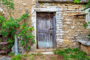 Old locked wooden door on a stone abandoned farmhouse. Image