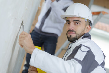 construction worker with wall plastering tools renovating apartment
