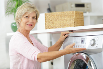 mature woman showing her washing machine controls