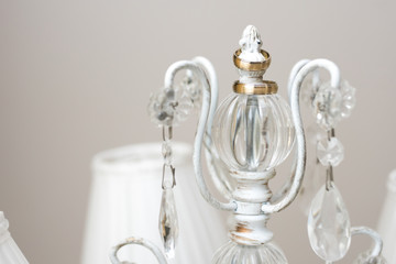 Golden wedding rings placed on white candlestick illuminated by morning light