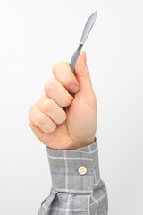 Male hand holds a medical scalpel on a white background