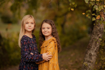 happy family, two sisters in the autumn park, girls smiling