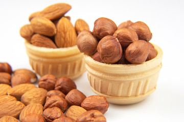Different nuts in a waffle basket on a white background. Vitamin wholesome food.