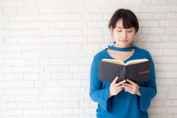 Beautiful of portrait young asian woman happiness relax standing reading book on concrete cement...